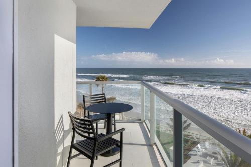 a balcony with two chairs and a table and the ocean at Renaissance Daytona Beach Oceanfront Hotel in Daytona Beach