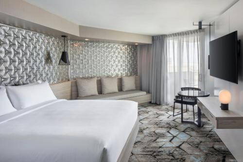a hotel room with a white bed and a table at Renaissance Daytona Beach Oceanfront Hotel in Daytona Beach