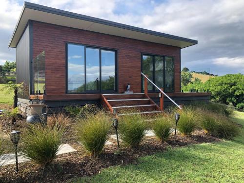 a small house with glass windows and a staircase at Little Wine Time at The Studio in Kerikeri
