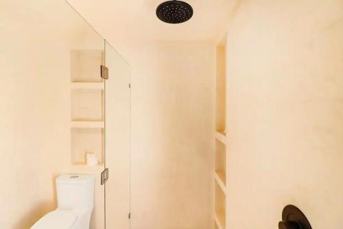 a bathroom with a toilet and a walk in shower at Zambo in Tulum
