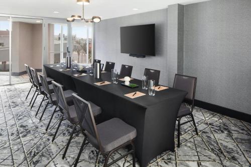 a long table in a room with chairs and a tv at Renaissance Daytona Beach Oceanfront Hotel in Daytona Beach