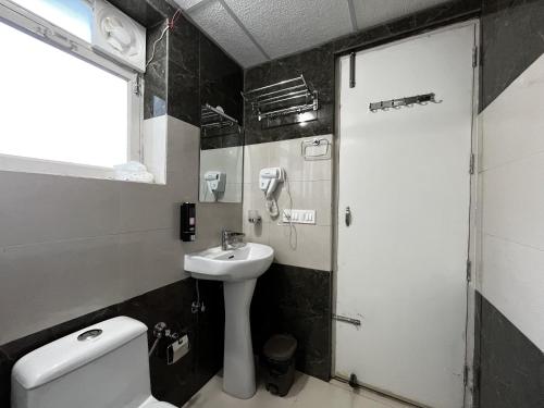 a bathroom with a sink and a toilet at Solan Woods - Cozy Studio Apartment in Chester Hills, Solan in Solan