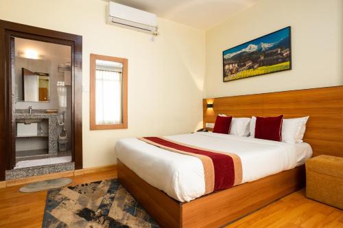 a bedroom with a large bed and a fireplace at Magnificent Hotel in Kathmandu