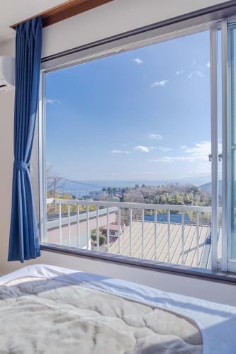 a bedroom with a large window with a view at Sea View Villa Atami in Atami