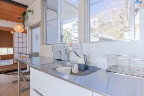 a kitchen with a sink and a large window at Sea View Villa Atami in Atami