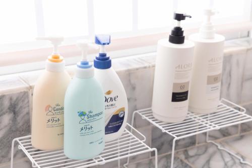 four bottles of shampoo and conditioner sit in a rack in a bathroom at Sea View Villa Atami in Atami