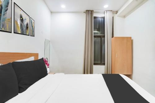 a bedroom with a black and white bed and a window at Super Townhouse Jagatpura Formerly Hotel Soft Patel in Jaipur