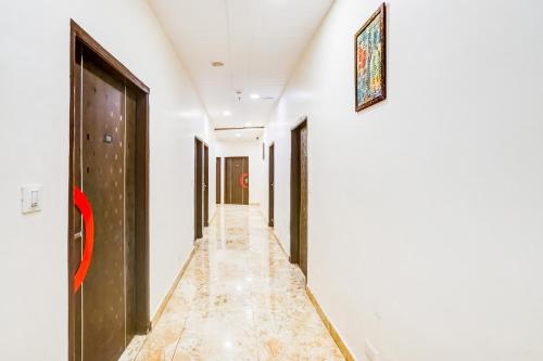 a corridor with white walls and a door and a tile floor at Super Townhouse Jagatpura Formerly Hotel Soft Patel in Jaipur