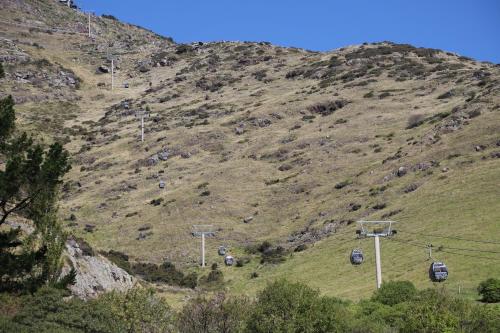 a mountain with a bunch of cars on a ski lift at Casterton Cottage, paradise garden with spa in Christchurch
