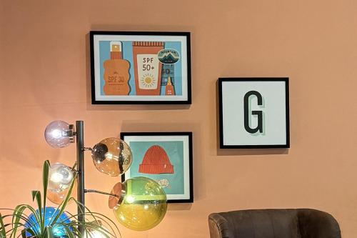 a room with three pictures on a wall with a lamp at Garner Hotel Berlin - Schöneberg by IHG in Berlin