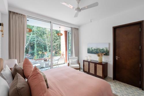 a bedroom with a large pink bed and a balcony at La Verona - 2,3,4 BHK Villas in Assagao with Private Pool, Garden, Caretaker, Kitchen & Security in Assagao