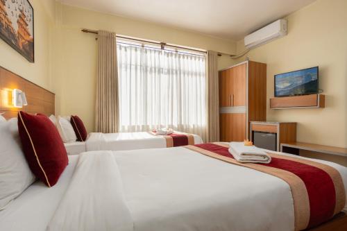 a hotel room with two beds and a window at Magnificent Hotel in Kathmandu