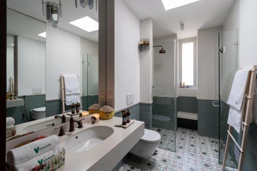 a bathroom with a sink and a toilet and a mirror at La Verona - 2,3,4 BHK Villas in Assagao with Private Pool, Garden, Caretaker, Kitchen & Security in Assagao