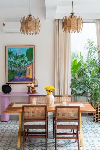 a dining room with a wooden table and chairs at La Verona - 2,3,4 BHK Villas in Assagao with Private Pool, Garden, Caretaker, Kitchen & Security in Assagao