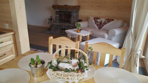 a living room with a table and chairs with a fireplace at Osada Brzezia in Kluszkowce