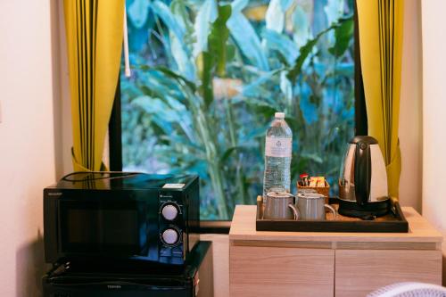 a microwave sitting on a table next to a coffee maker at Katiliya Park Villa in Mae Chan