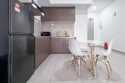 a kitchen with a table and chairs and a refrigerator at Alinea Luxury Condominiums, Shah Alam - Smarthome in Shah Alam