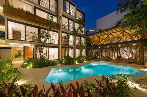 a swimming pool in front of a building at Xielo in Tulum