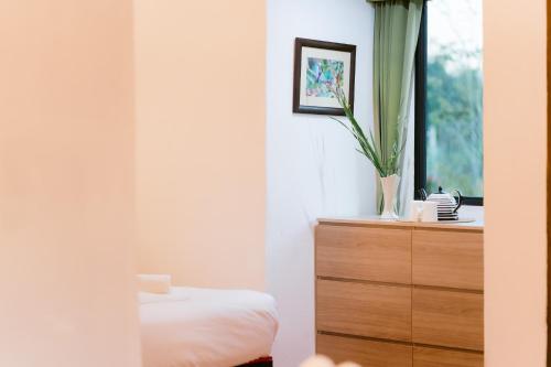 a bedroom with a dresser and a window at Katiliya Park Villa in Mae Chan