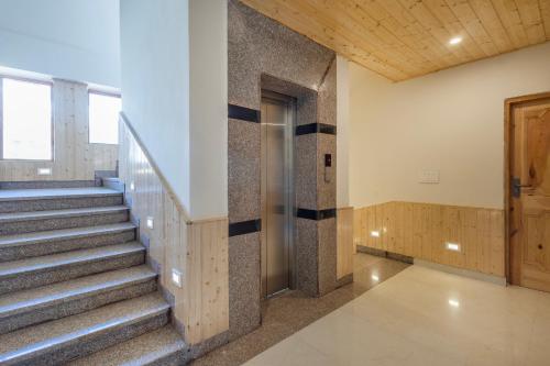 a hallway with stairs and a door in a building at Treebo Premium Silverstone Resort With Mountain Valley View in Manāli