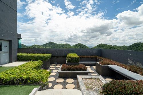 a garden with two benches and a fence at Mountain-view 1BR 9F Sriracha byน้องมังคุด NoParking in Ban Fang Daeng