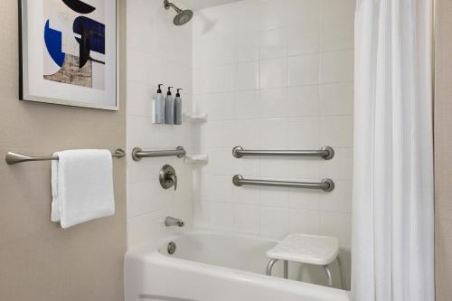 a bathroom with a white tub and a toilet at Courtyard Los Angeles Sherman Oaks in Sherman Oaks