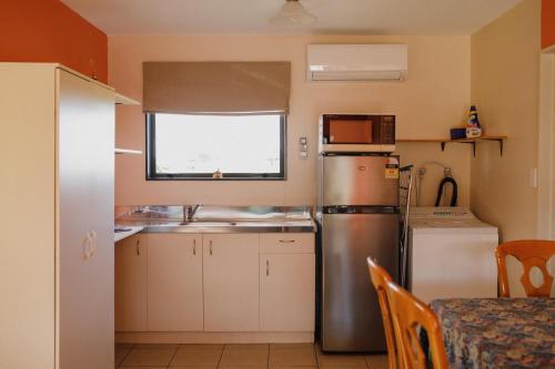 a kitchen with a stainless steel refrigerator and a window at North Eyre Retreat in Christchurch