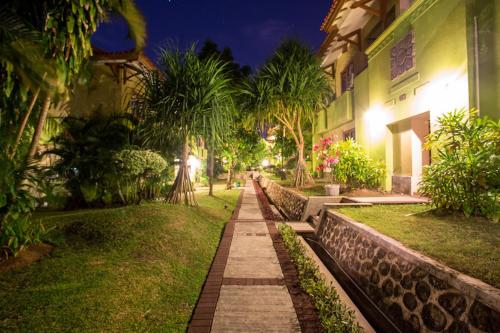 a walkway in front of a building at night at Kana Suites Jimbaran By Fays Hospitality in Nusa Dua