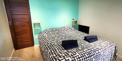a bedroom with a bed with two blue pillows on it at Villa Ocean neuve piscine double et vue mer proche du centre ville in Les Avirons