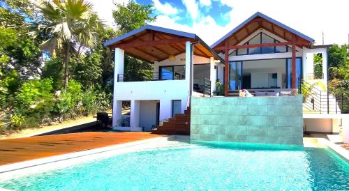 a villa with a swimming pool and a house at Villa Ocean neuve piscine double et vue mer proche du centre ville in Les Avirons