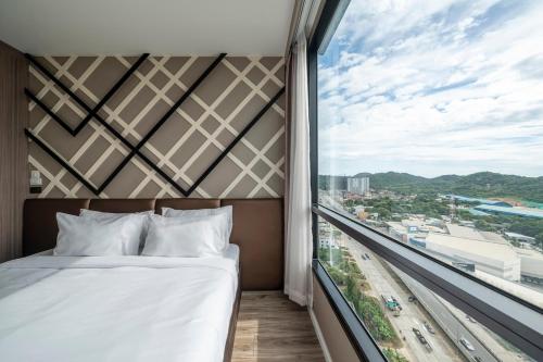 a bed in a room with a large window at 360 Seaview 2BR 15F Sriracha Beach by น้องมังคุด in Ban Fang Daeng