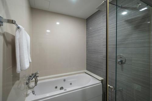 a bathroom with a tub and a glass shower at 360 Seaview 2BR 15F Sriracha Beach by น้องมังคุด in Ban Fang Daeng