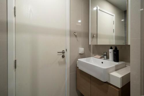 a white bathroom with a sink and a mirror at 360 Seaview 2BR 15F Sriracha Beach by น้องมังคุด in Ban Fang Daeng