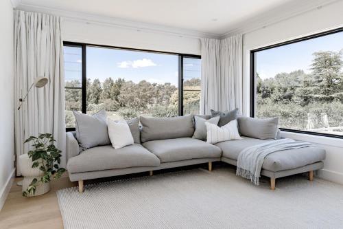 マッジーにあるElegant Modern Home!のソファと大きな窓のあるリビングルーム