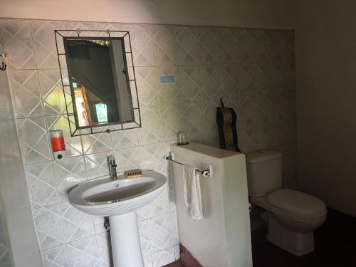 a bathroom with a sink and a toilet at Bwana Tembo Safari Camp in Paraa