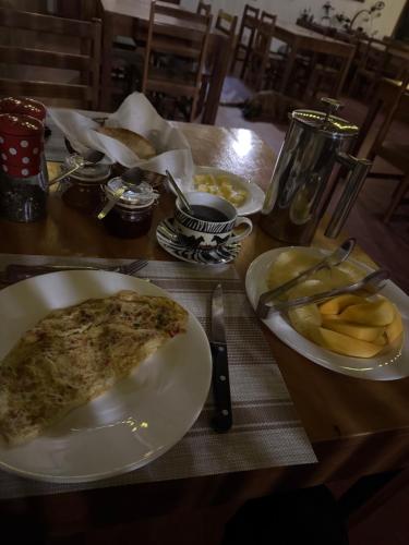 a table with a plate of pizza and french fries at Bwana Tembo Safari Camp in Paraa