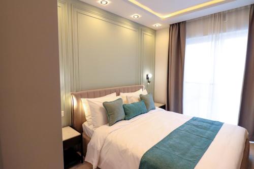 a bedroom with a bed with pillows and a window at Pietro Boutique Hotel and Residences in Għarb