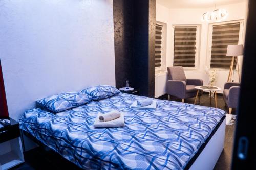 a bedroom with a bed with towels on it at Apartmani Đorđević in Soko Banja