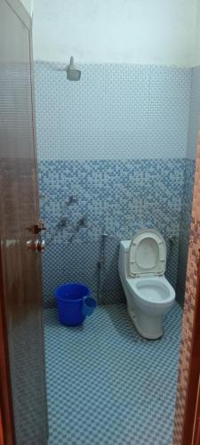 a bathroom with a toilet in a blue tiled room at Tabish INN in Trivandrum