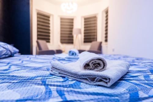 a stack of towels sitting on top of a bed at Apartmani Đorđević in Soko Banja