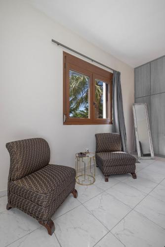 a living room with two chairs and a table at Prestige Residence Rhodes in Ialyssos