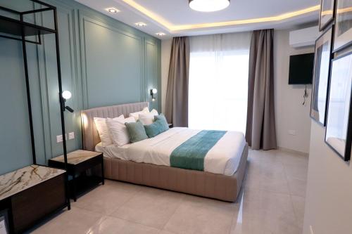 a bedroom with a bed and a large window at Pietro Boutique Hotel and Residences in Għarb