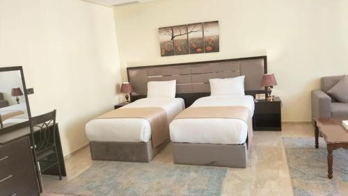 a hotel room with two beds and a couch at City View Hotel- Managed by Arabian Link International in Kuwait