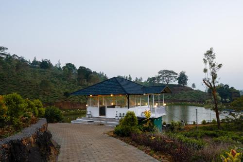 a pavilion on the side of a body of water at jungle view resort in Mananthavady