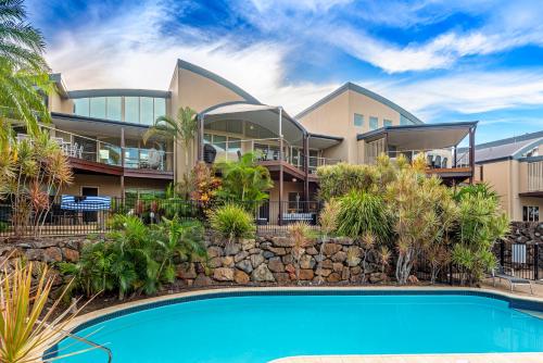a house with a swimming pool in front of it at Cooinda Gardens on Hamilton Island by HIHA in Hamilton Island