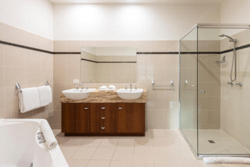a bathroom with two sinks and a shower at Cooinda Gardens on Hamilton Island by HIHA in Hamilton Island
