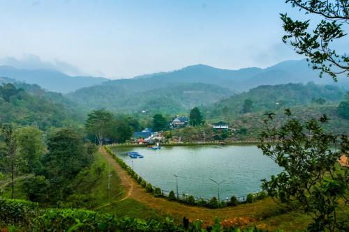 a view of a lake with mountains in the background at jungle view resort in Mananthavady