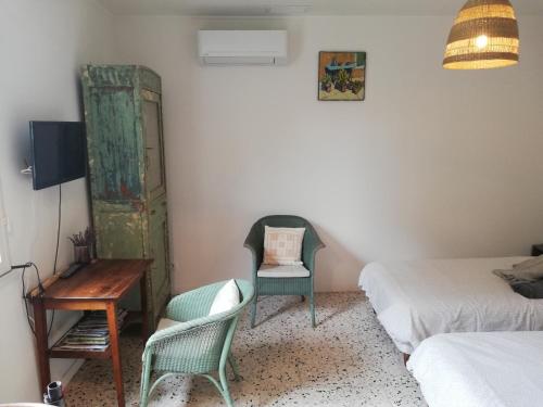 Cette chambre comprend deux lits, une chaise et un bureau. dans l'établissement Gîte de la treille, à LʼIsle-sur-la-Sorgue