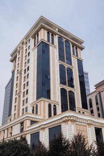 a tall building with a lot of windows at Spacious and Premium 2 Bedroom Apartment with Panoramic Terrace and Rudaki Park View in Prime Dushanbe Location in Dushanbe