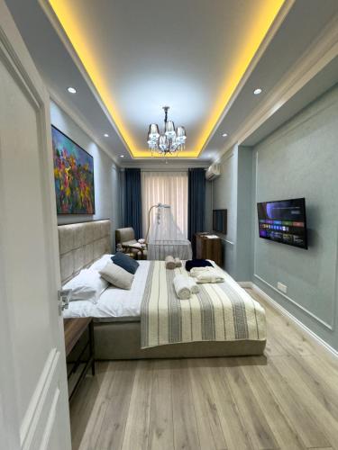 a bedroom with a large bed and a chandelier at Spacious and Premium 2 Bedroom Apartment with Panoramic Terrace and Rudaki Park View in Prime Dushanbe Location in Dushanbe